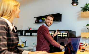 Cropped shot of two coworkers talking in an office cafeteria