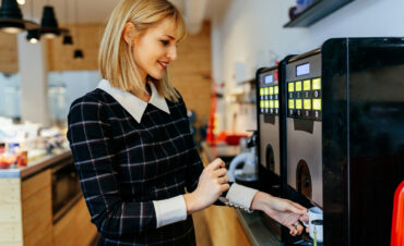 Young attractive woman making a coffee in an office cafeteria